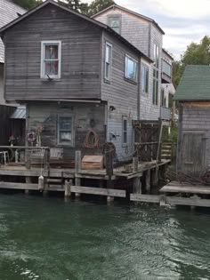 an old wooden house sitting next to a body of water with bicycles on the dock