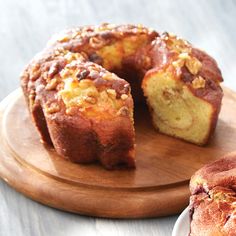 a bundt cake on a wooden platter with one slice cut out and another half eaten