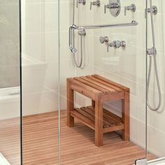 a wooden bench sitting in front of a shower