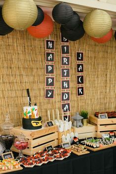 an assortment of food on display at a buffet table with paper lanterns hanging from the ceiling