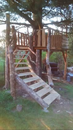 a tree house built into the side of a hill with stairs leading up to it