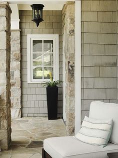 a white couch sitting on top of a stone covered porch