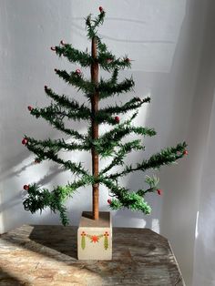 a small christmas tree sitting on top of a wooden table