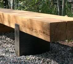 a wooden bench sitting on top of a gravel covered ground