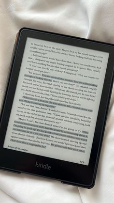 a kindle sitting on top of a white sheet