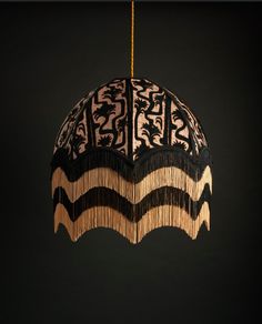 a lamp hanging from the ceiling with fringes on it's sides and an intricate design