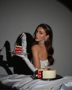 a woman sitting at a table with a cake