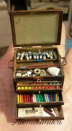 an open wooden box filled with lots of art supplies