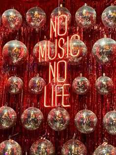 there are many disco balls hanging from the ceiling with words on them that say no music, no life