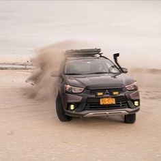 a car is driving through the sand with it's front wheels in the air