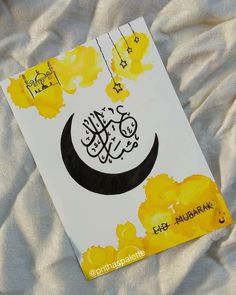 a book with arabic writing on it sitting on a white sheet covered in yellow flowers