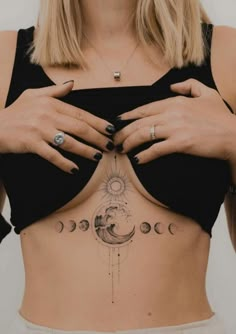 a woman's stomach with tattoos on it and the moon in the sky above her