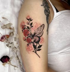 a woman's arm with a butterfly and flowers tattoo on the left side of her body