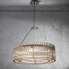 a chandelier hanging from the ceiling in a room with concrete walls and flooring