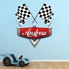 a wall decal with the name and two checkered flags on it next to a toy car