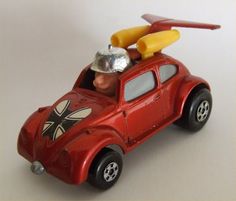 a toy car with an airplane on the roof, and a man in a helmet