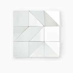 a white square shaped mirror on the wall