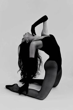 black and white photo of a woman in tights on the floor with her legs spread out