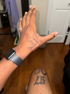 a man's arm with a tattoo on it and his hand holding the wrist