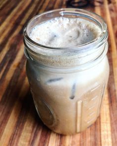 a glass jar filled with liquid sitting on top of a wooden table