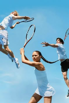 three tennis players are jumping in the air with their rackets