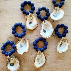 several pieces of oyster with blue beads are arranged on a wooden surface, including one in the middle