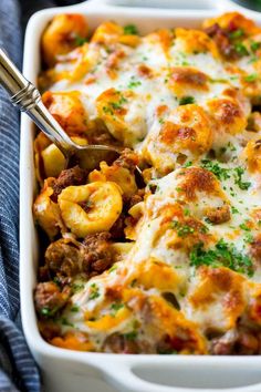 a casserole dish with meat, cheese and vegetables in it on a blue towel