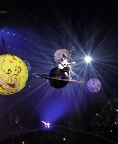 two cartoon characters are suspended in the air above an audience at a concert or show