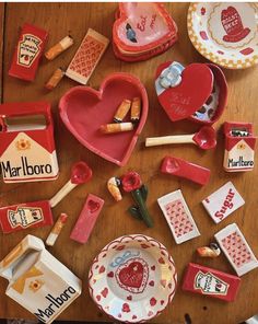 a wooden table topped with lots of red and white dishes covered in miniature food items