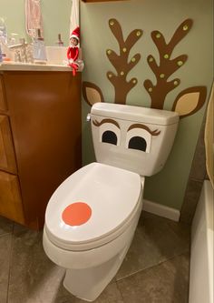 a bathroom with a toilet decorated like a reindeer