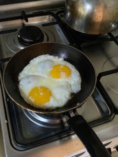 two fried eggs in a frying pan on the stove