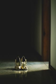 a pair of shoes sitting on top of a floor next to a doorway in a dark room