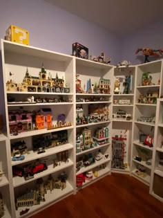 a room filled with lots of white shelves covered in toy figurines and toys