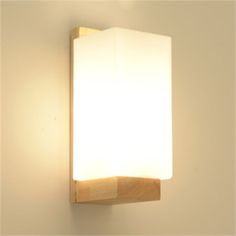 a light that is on the side of a wall with a wooden frame around it