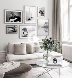 a living room filled with white furniture and pictures on the wall above it's coffee table