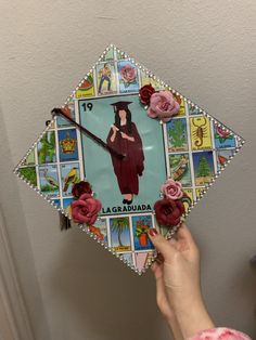 a hand holding a clock with an image of a woman in graduation gown and flowers on it