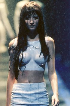 a woman walking down a runway in the rain