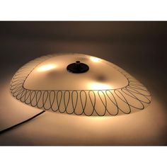 a lamp that is sitting on top of a white surface with wires coming out of it