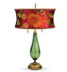 a green glass lamp with a red shade on the bottom and gold trimmings