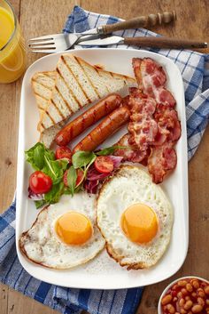 a white plate topped with eggs, bacon and toast