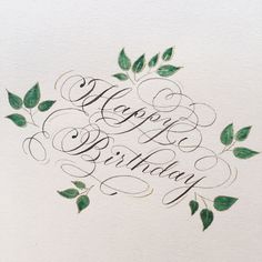 the words happy birthday written in cursive calligraphy on a piece of paper