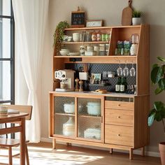 a wooden cabinet with glass doors and shelves filled with dishes on top of it next to a dining room table