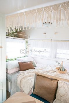 a bedroom with a bed, window and hanging decorations on the wall above it's headboard