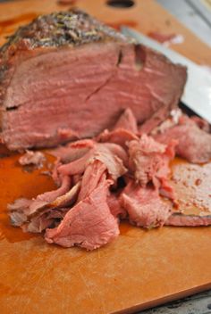 a piece of meat on a cutting board with a knife