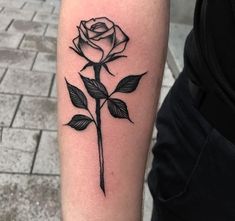 a black and white rose tattoo on the arm