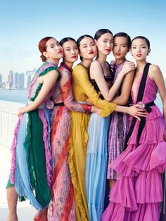 four women in colorful dresses standing together on the cover of a magazine, with chinese writing