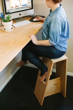 a woman sitting at a desk using a computer