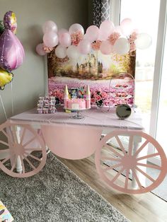 a pink cart with balloons and candles on it