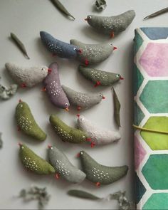 several small birds sitting on top of a table next to a roll of paper and scissors