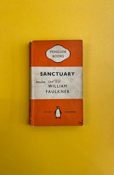 the penguin book sanctuary by william paul faulner is displayed on a yellow wall